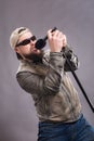 Bearded emotional rock singer with microphone studio portrait.