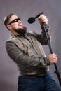 Bearded emotional rock singer with microphone studio portrait.