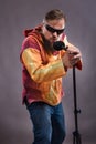 Bearded emotional rock singer with microphone studio portrait.