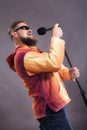 Bearded emotional rock singer with microphone studio portrait.