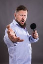 Bearded emotional singer with micriphone dressed in shirt Royalty Free Stock Photo