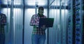 Bearded IT engineer using laptop in server room Royalty Free Stock Photo