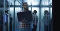 Bearded IT engineer using laptop in server room Royalty Free Stock Photo