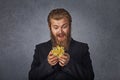 Bearded excited man opening looking at golden gift isolated on grey. Winter holiday concept