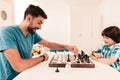 Bearded Father and Son Playing Chess on Table.