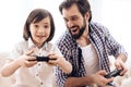 Bearded father with son plays computer game using game controllers. Royalty Free Stock Photo