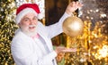 Bearded grandfather senior man celebrate christmas. Kind grandpa with toy. Sparkling decorations. Decorating home Royalty Free Stock Photo