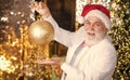 Bearded grandfather senior man celebrate christmas. Kind grandpa with toy. Sparkling decorations. Decorating home Royalty Free Stock Photo