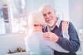 Bearded grey-haired elderly husband hugging his appealing wife Royalty Free Stock Photo