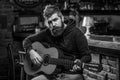 Bearded guitarist plays. Play guitar. Beard hipster man sitting in a pub. Live music. Black and white Royalty Free Stock Photo