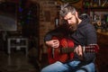 Bearded guitarist plays. Play the guitar. Beard hipster man sitting in a pub. Live music. Guitars and strings. Bearded Royalty Free Stock Photo