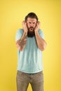 Bearded guy dislike music. Irritating sound. Man listening music wireless headphones. Equalizer settings. Awful sound Royalty Free Stock Photo