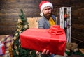 Bearded guy with eyeglasses carry present box. Delivery christmas present. Delivery service. Christmas is coming. Gifts