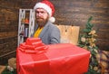 Bearded guy with eyeglasses carry present box. Delivery christmas present. Delivery service. Christmas is coming. Santa