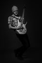 Bearded guy plays rock guitar on dark gray background, black and white