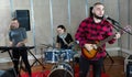 Bearded guy soloist playing guitar in studio