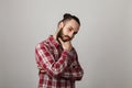 Bearded handsome man is thinking in red squared shirt on grey ba Royalty Free Stock Photo