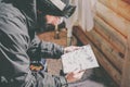 Bearded handsome snowboarded taking rest after ride session.Young man looks at the mountain map on sunny terrace Royalty Free Stock Photo