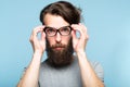 Bearded hipster fixing cat eye glasses geeky man