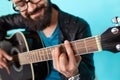 Bearded hipster man hand playing on acoustic guitar. Royalty Free Stock Photo