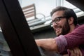 A bearded hipster man wearing a red button down shirt smiling with his prescribed glasses to see more clearly what is in the Royalty Free Stock Photo