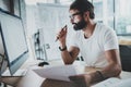 Bearded hipster professional wearing eye glasses working at modern loft studio-office with desktop computer.White blank