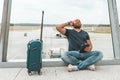 Bearded hipster traveller is waiting for his flight and listening music