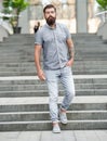 bearded hipster walking downstairs. full length of hipster with beard. caucasian hipster outdoor