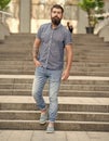 bearded hipster walking downstairs. full length of hipster with beard. caucasian hipster outdoor