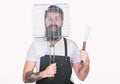 Bearded hipster wear apron for barbecue. Tips cooking meat. Tools for roasting meat outdoors. How choose meat for steak