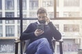 Bearded hispanic man in black pullover using mobile phone application for mobile blogging.Confident young coworker guy Royalty Free Stock Photo