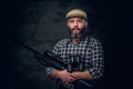 Bearded hunter holds a rifle. Royalty Free Stock Photo