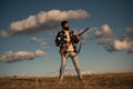 Bearded hunter man holding gun and walking in forest. Hunter with shotgun gun on hunt.