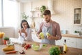 Bearded husband taking lettuce while cooking salad for wife Royalty Free Stock Photo