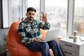 Bearded indian man showing thumb up with laptop on knees Royalty Free Stock Photo