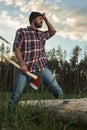 Bearded Lumberjack holding a big Ax in one Hand and wipes the Sw