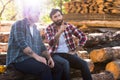 bearded lumberjack pointing by finger to sitting colleague