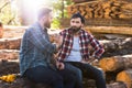 bearded lumberjacks sitting on logs and shaking hands Royalty Free Stock Photo