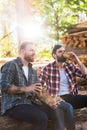 bearded lumberjacks with smartphone drinking coffee from papers cups