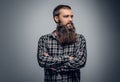 Bearded male with crossed arms, dressed in a plaid shirt. Royalty Free Stock Photo