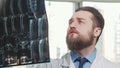 Bearded male doctor examining mri scan of his patient Royalty Free Stock Photo