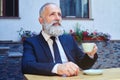 Bearded male drinking coffee while sitting