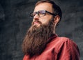 A bearded male in eyeglasses dressed in a red shirt.