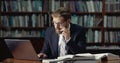 Bearded male with laptop in library