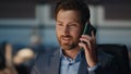 Bearded man answering call at night corporate office closeup. Man talking phone Royalty Free Stock Photo