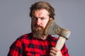 Bearded man with axe. Logger tool. Guy in checkered shirt with hatchet. Canadian lumberjack with ax. Royalty Free Stock Photo