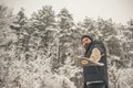 Bearded man with axe in snowy forest.