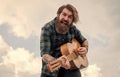 bearded man being a rock star. casual male guitariston sky background. concept of music and vocal. man playing the Royalty Free Stock Photo