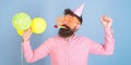 Bearded man in birthday cap and huge crazy glasses dancing, party hard, fun time concept. Hipster with trimmed beard and