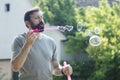 Bearded man blowing soap bubbles